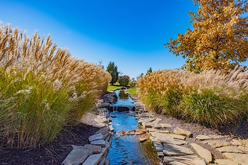 Stone lined stream with decorative grass at Gezer Park Leawood KS Photo by Ken Jansen Realtor